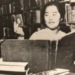 Chicko Tachihata, FLH scholarship winner in 1962, examines the smallest and largest books for sale. - Honolulu Star-Bulletin